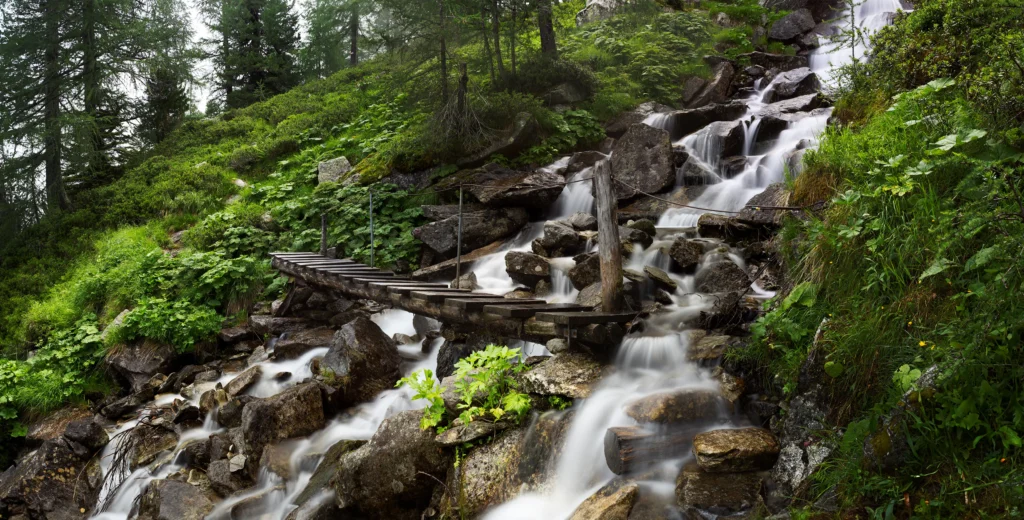 Long exposure photograph of a bridge with water and clouds smoothed, achieved with a variable ND filter